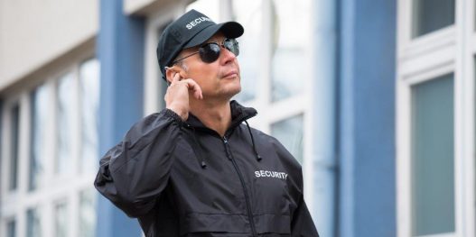 security-guard-using-mobile-phone-outside-building_sizel